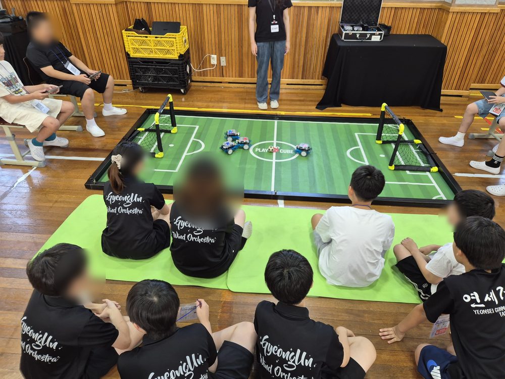 미니 로봇축구, 대기하는 학생들이 경기장 둘레에 앉아 함께 관전합니다